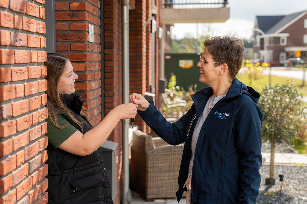 Nieuwe bewoner ontvangt sleutel van verhuurconsulent Dianne